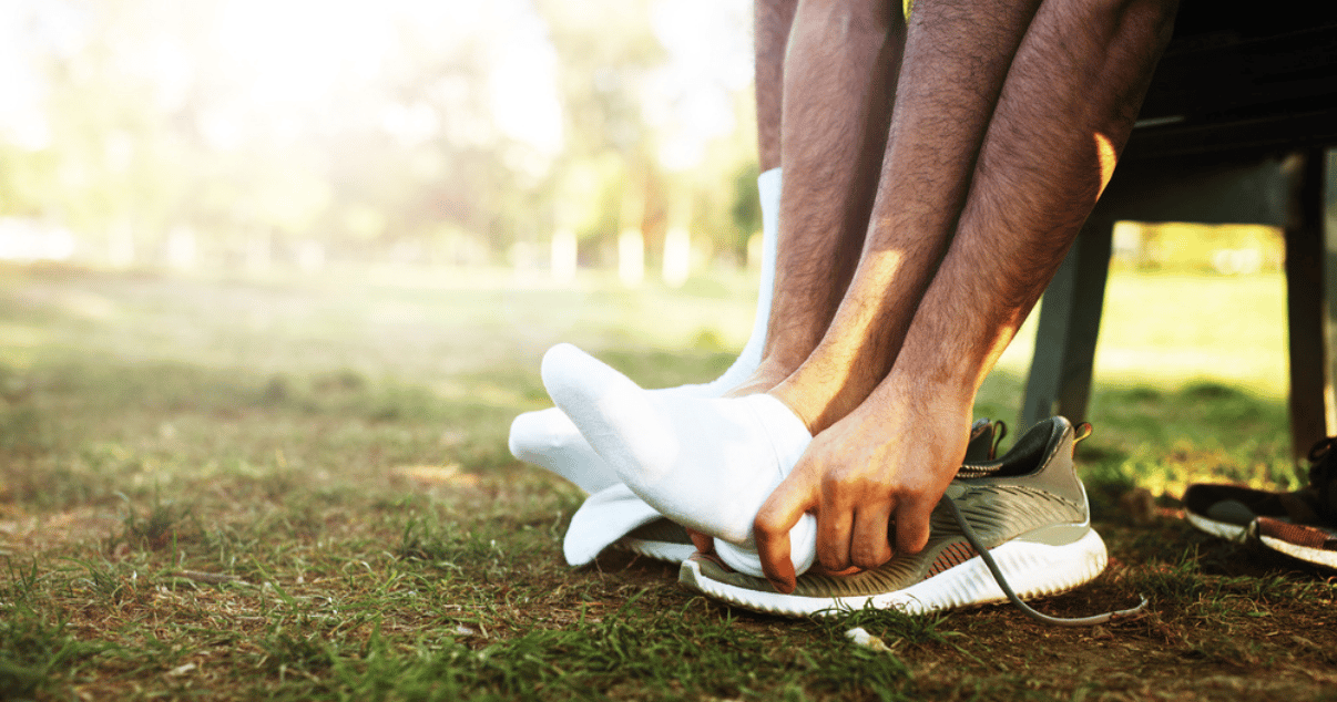 Man changing into new socks getting ready to go for a run while remembering the tips for preventing atheles foot infection