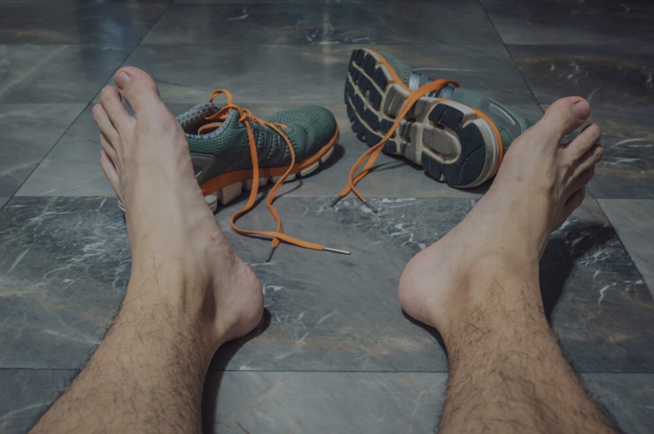 man taking sweaty shoes off wondering which athletes foot treatment is best for him man taking sweaty shoes off wondering which athletes foot treatment is best for him